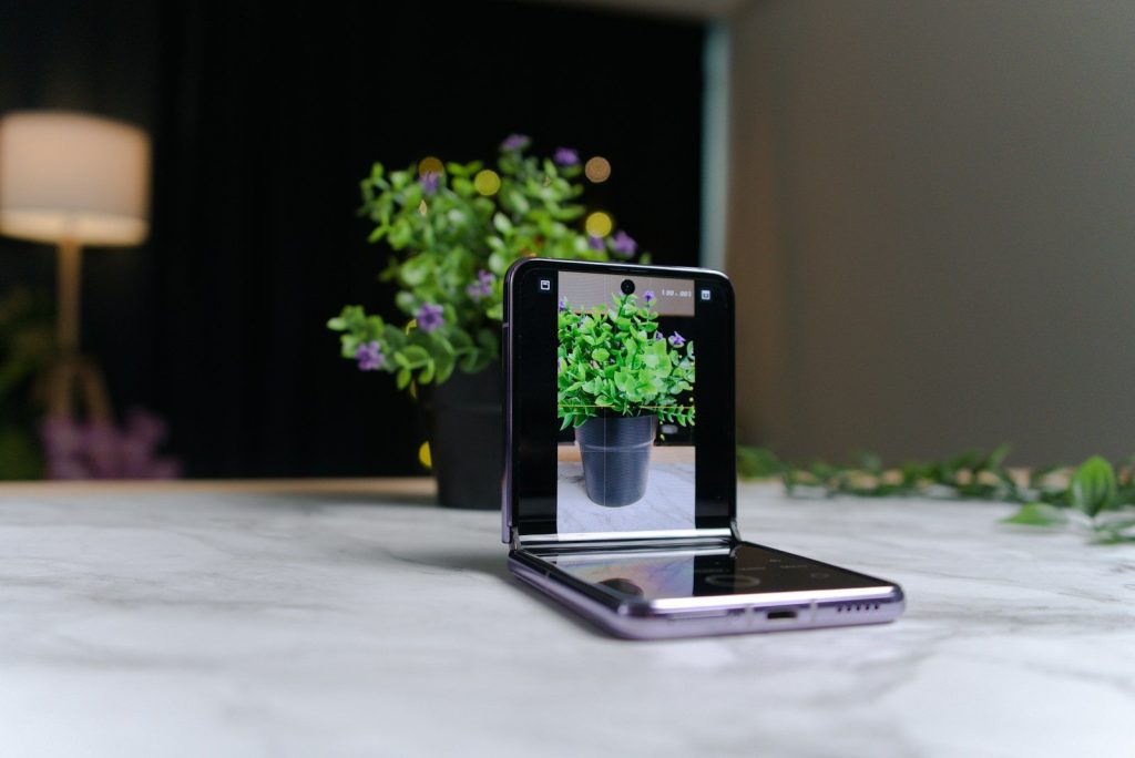 a cell phone sitting on top of a table next to a potted plant