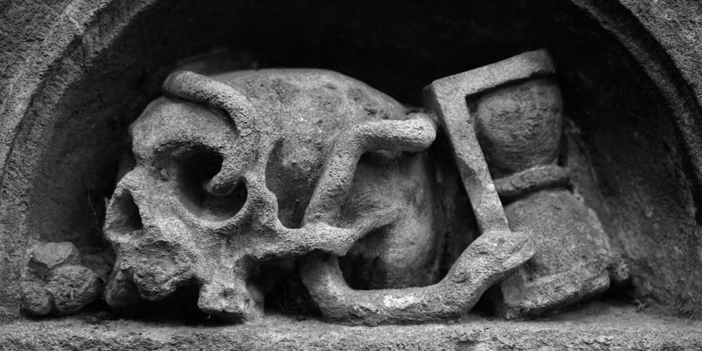A skull, an hourglass, and a snake in stone.