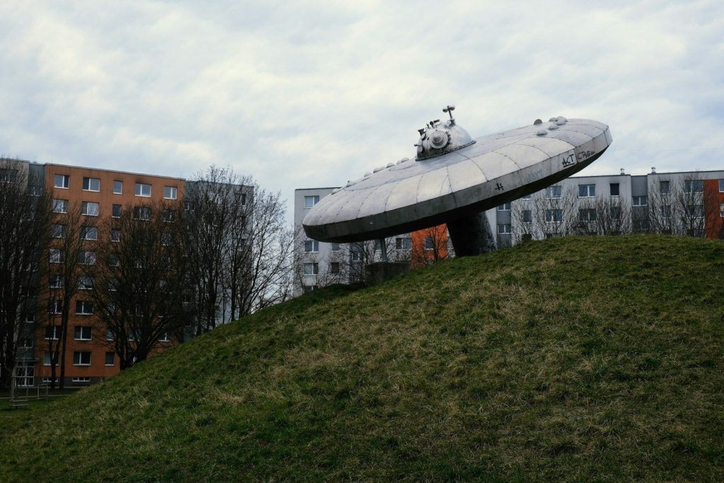 a large object sitting on top of a lush green hillside