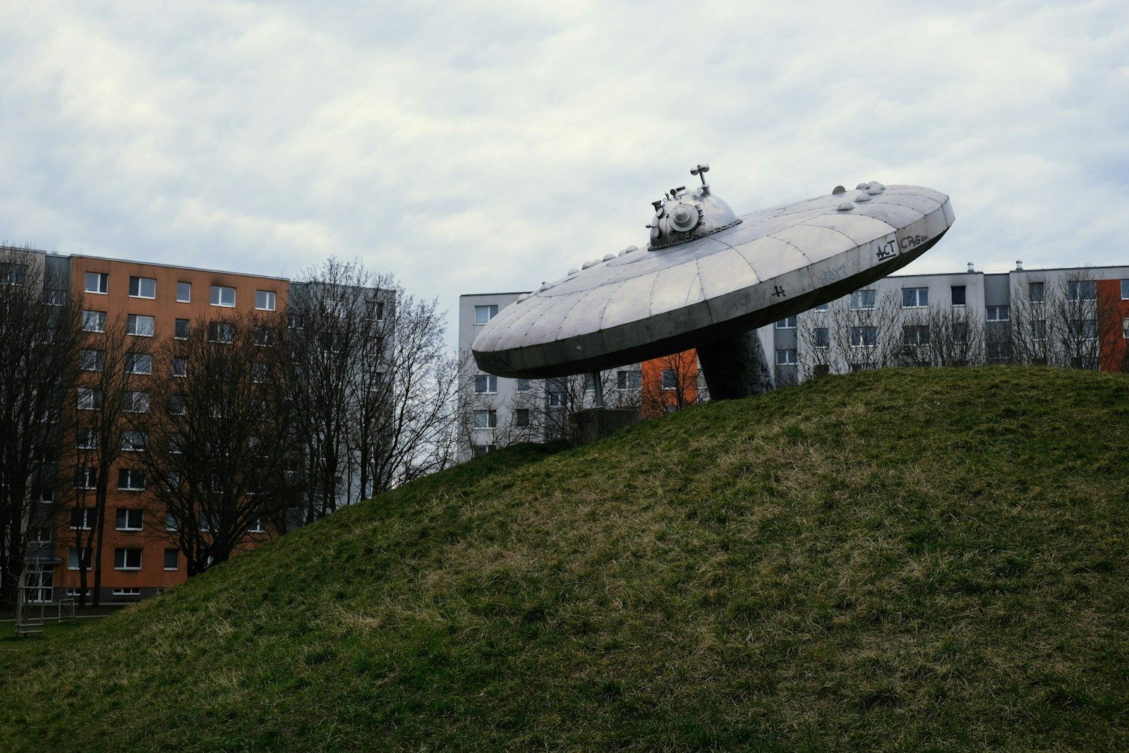 a large object sitting on top of a lush green hillside