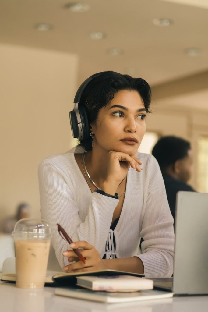 Woman wearing headphones with hand on chin