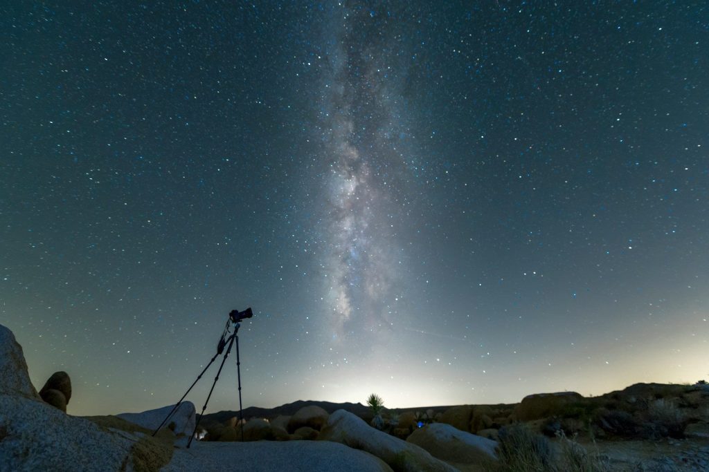 black tripod on snow covered ground under starry night