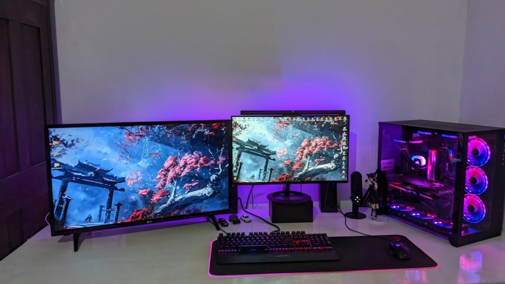 a desk with a keyboard and two monitors