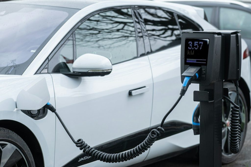 White electric car charging at a station.