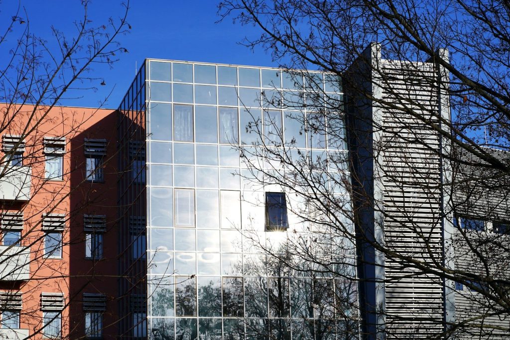 A tall building with a lot of windows next to trees