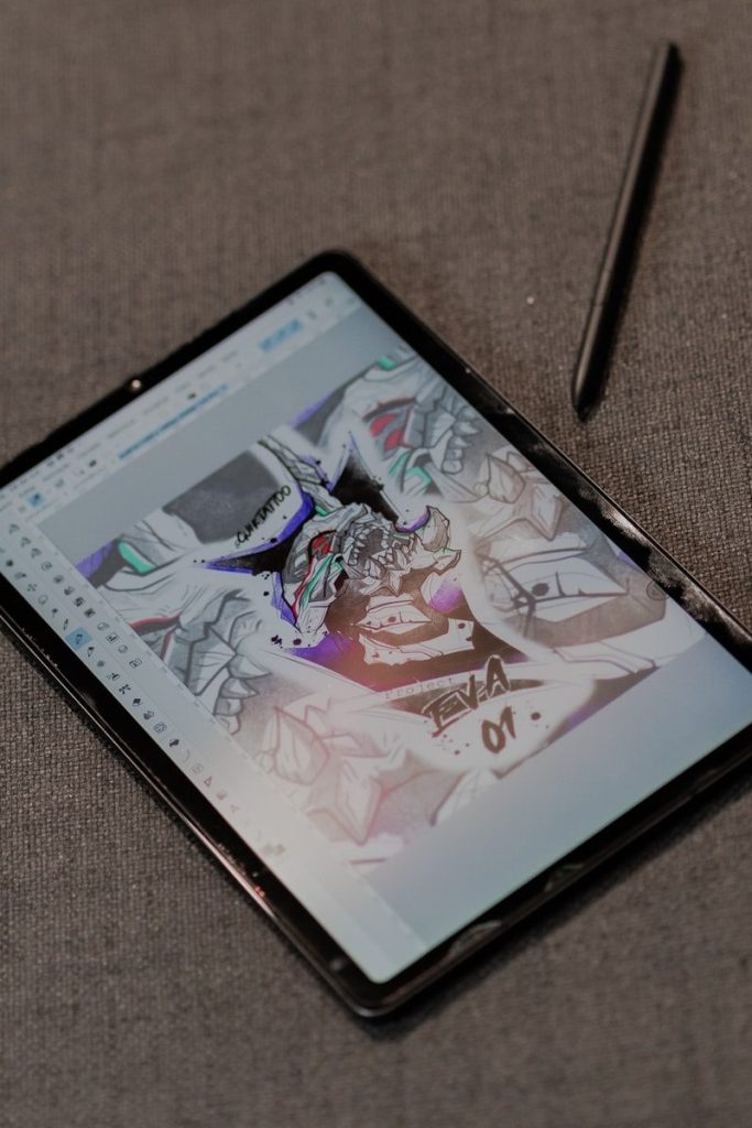 A tablet with a pen sitting on top of it