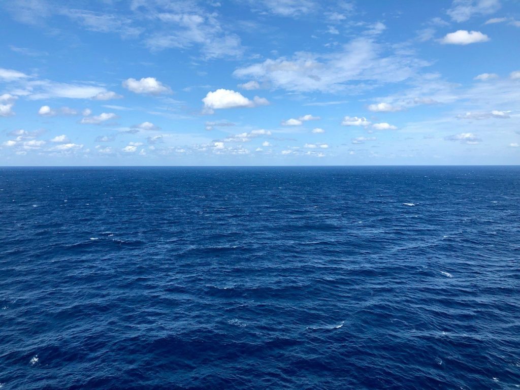 blue sea under blue sky and white clouds during daytime