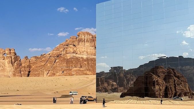 a desert scene with a large mirror in the middle