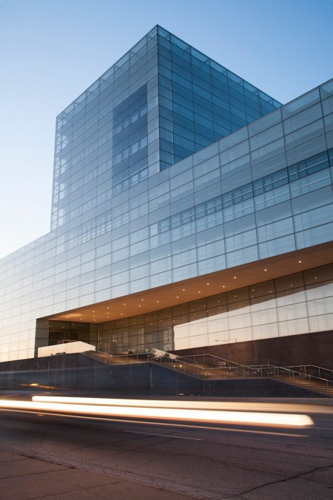 modern glass building at dusk with light trails