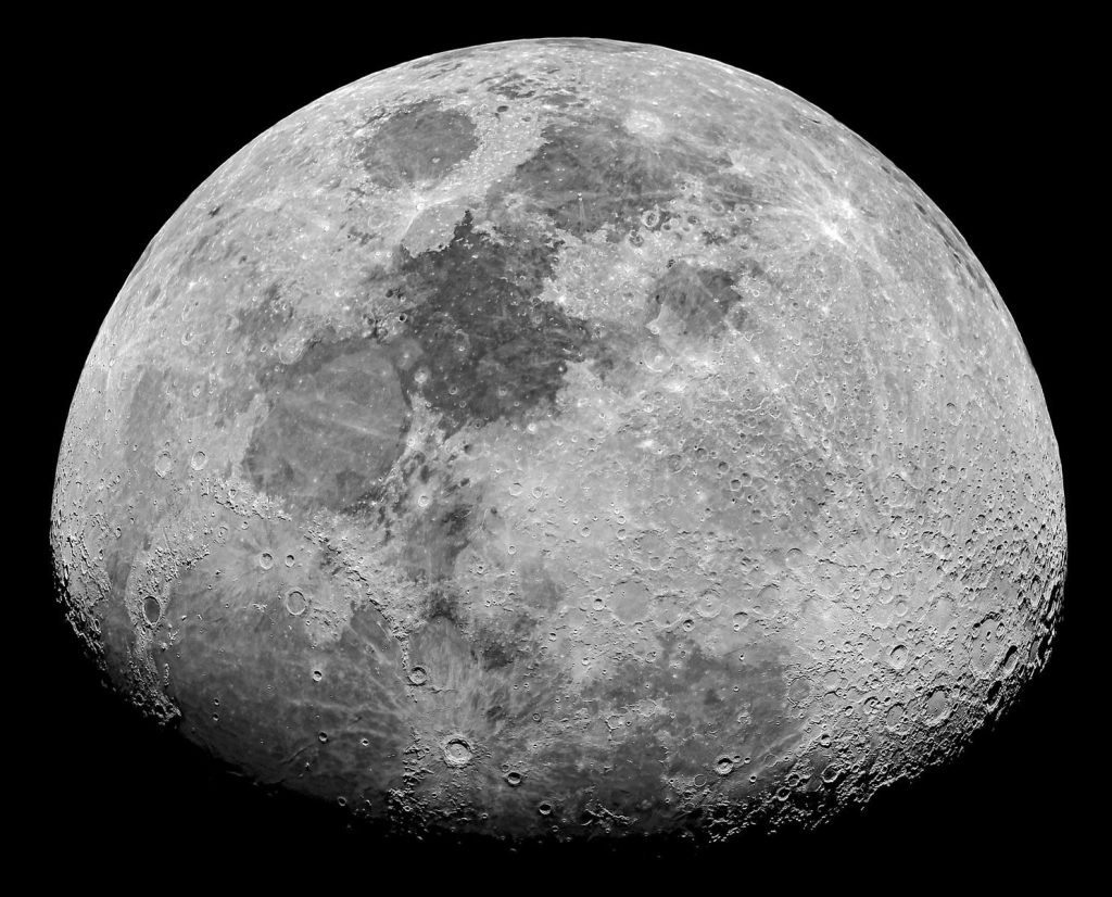 Close-up monochrome image of the moon's surface highlighting craters and textures.