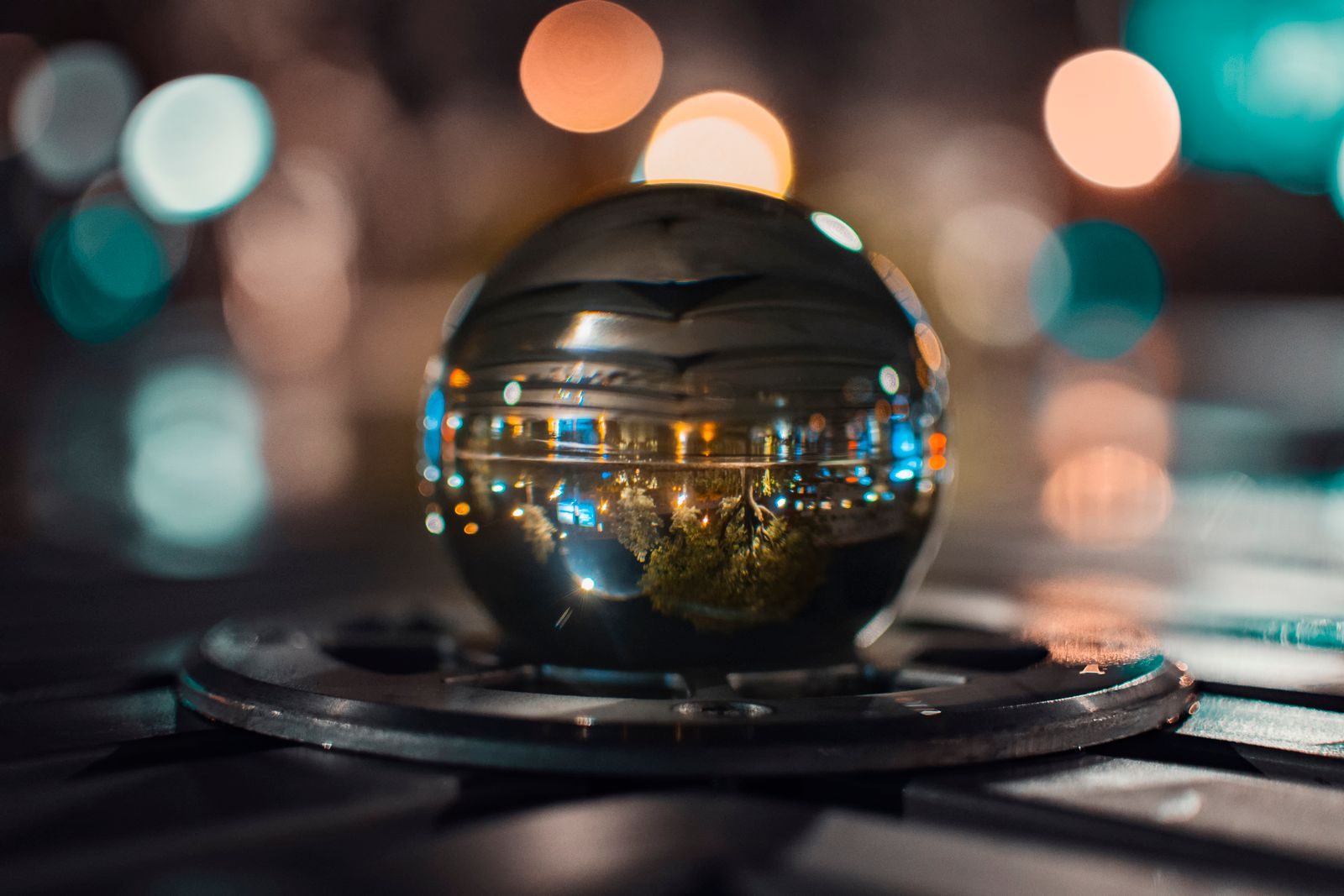 A glass sphere reflects vibrant city lights with a dreamy bokeh effect.