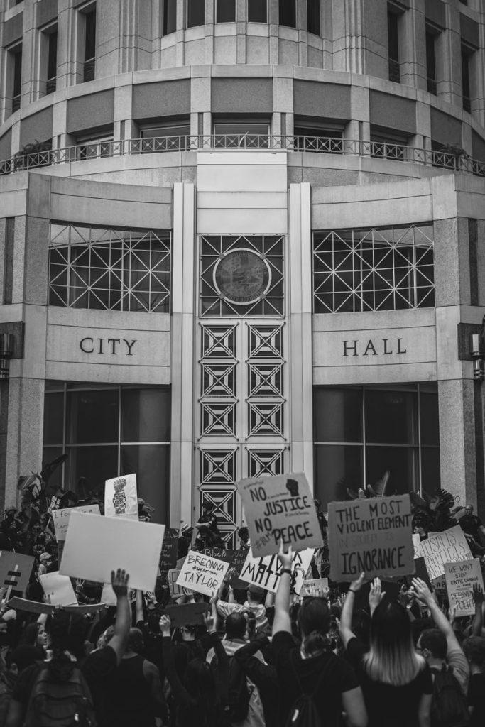 Black and white photo of a crowd protesting at a city hall.