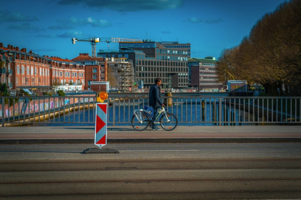 A cyclist rides across a city bridge.
