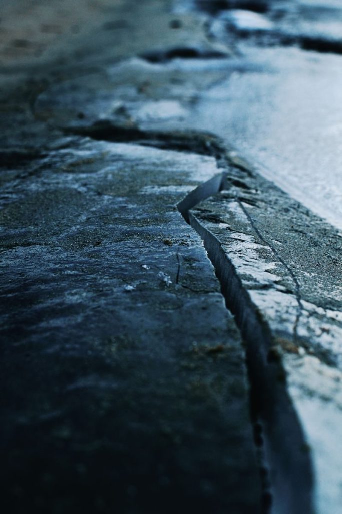 A close-up view of a cracked ice surface with visible textures and cold tones.