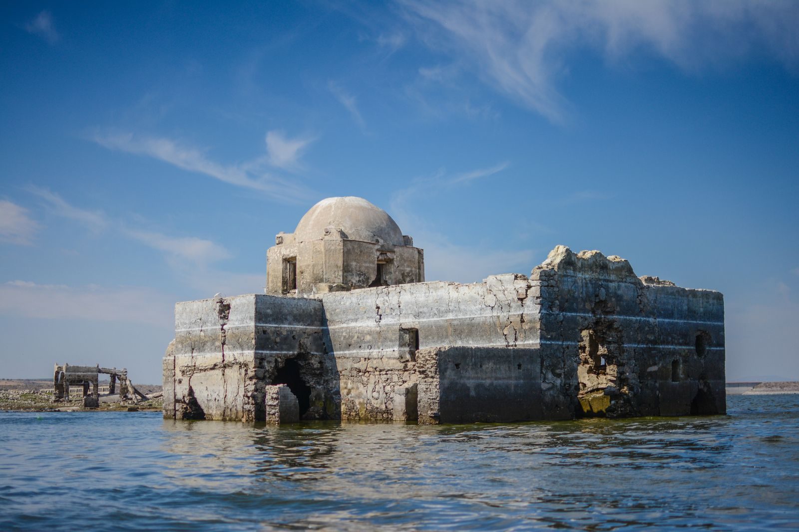 View of the sunken historic temple in Guanajuato, Mexico emerging from the water under a clear blue sky.