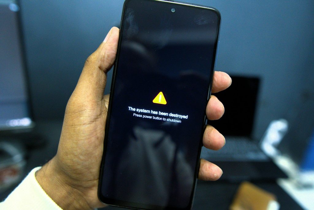 Phone shows a system failure warning message.