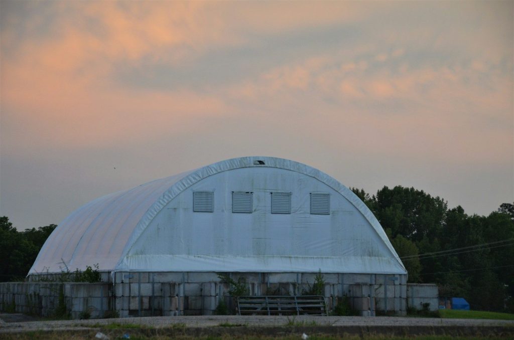 a large white building sitting in the middle of a field