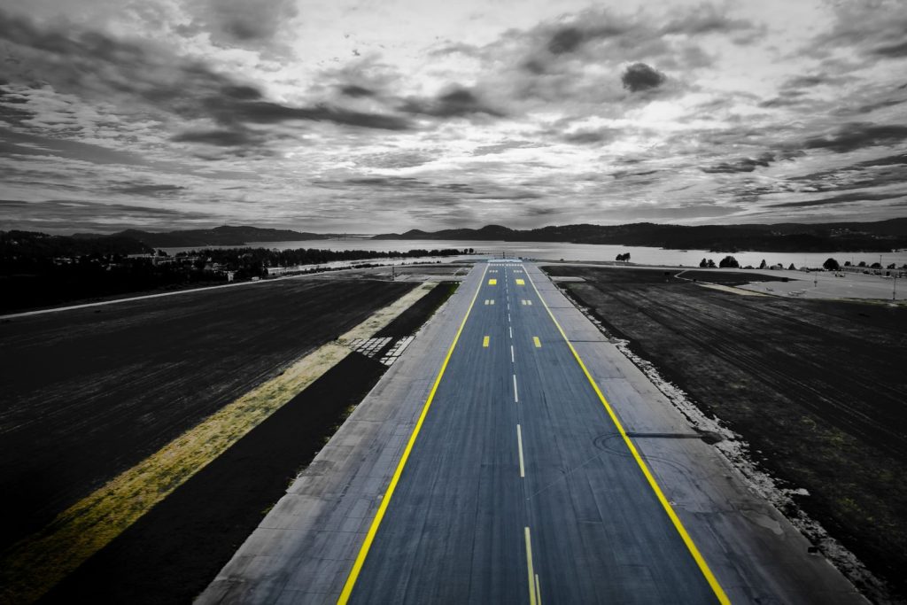 Aerial shot of a runway at Kjevik Airport, Norway under a dramatic sky