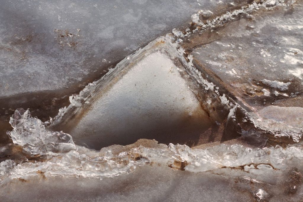 Intriguing close-up of ice formations melting and refreezing in a geometric pattern.