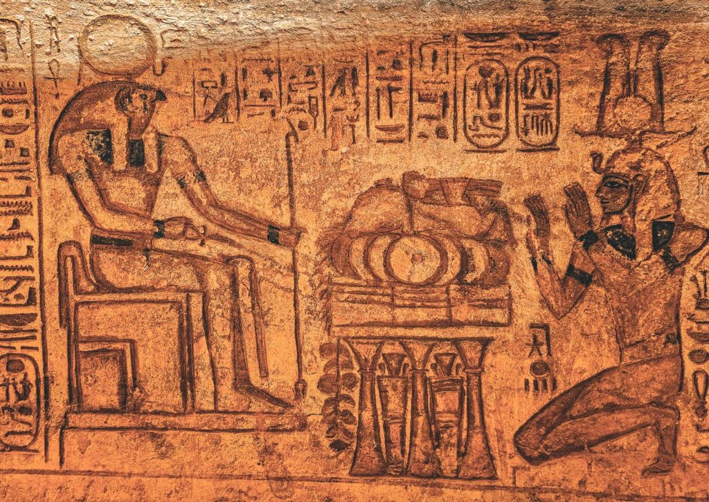 Detailed ancient Egyptian wall inscription with hieroglyphics and figures in sepia tones.