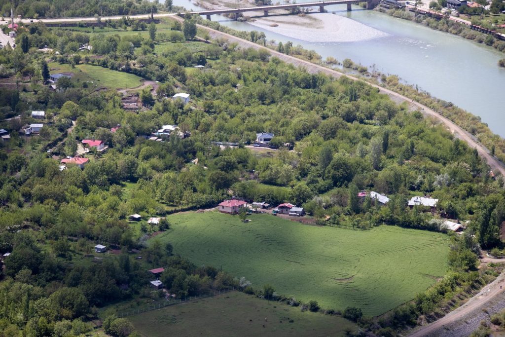 Aerial view of the verdant landscape and river in Palu, Elazığ, Türkiye, showcasing nature's beauty.