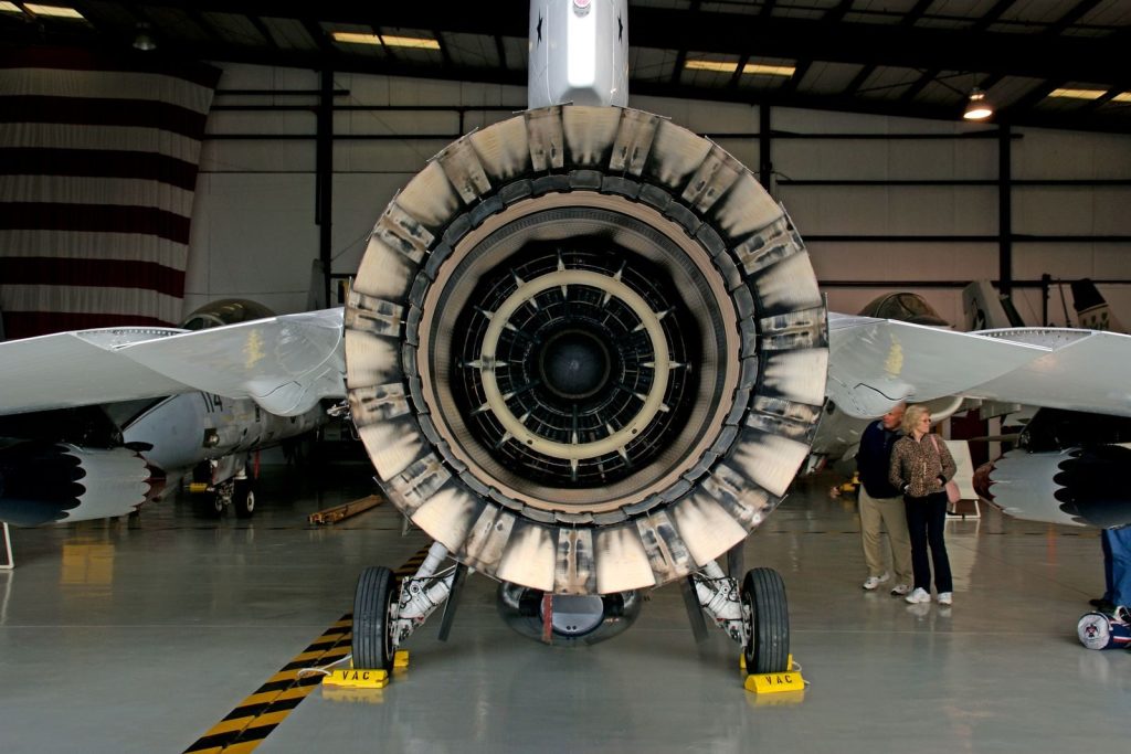 Detailed photograph of a jet engine exhaust with visible technical components inside a hangar.
