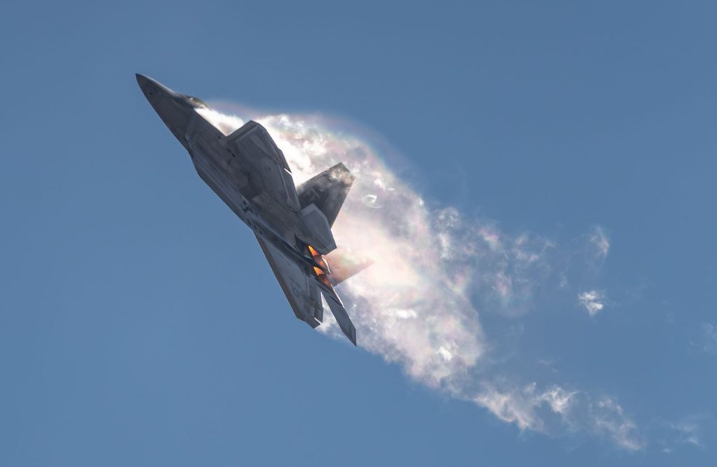 F-22 Raptor performing a dramatic airshow maneuver in San Diego skies.