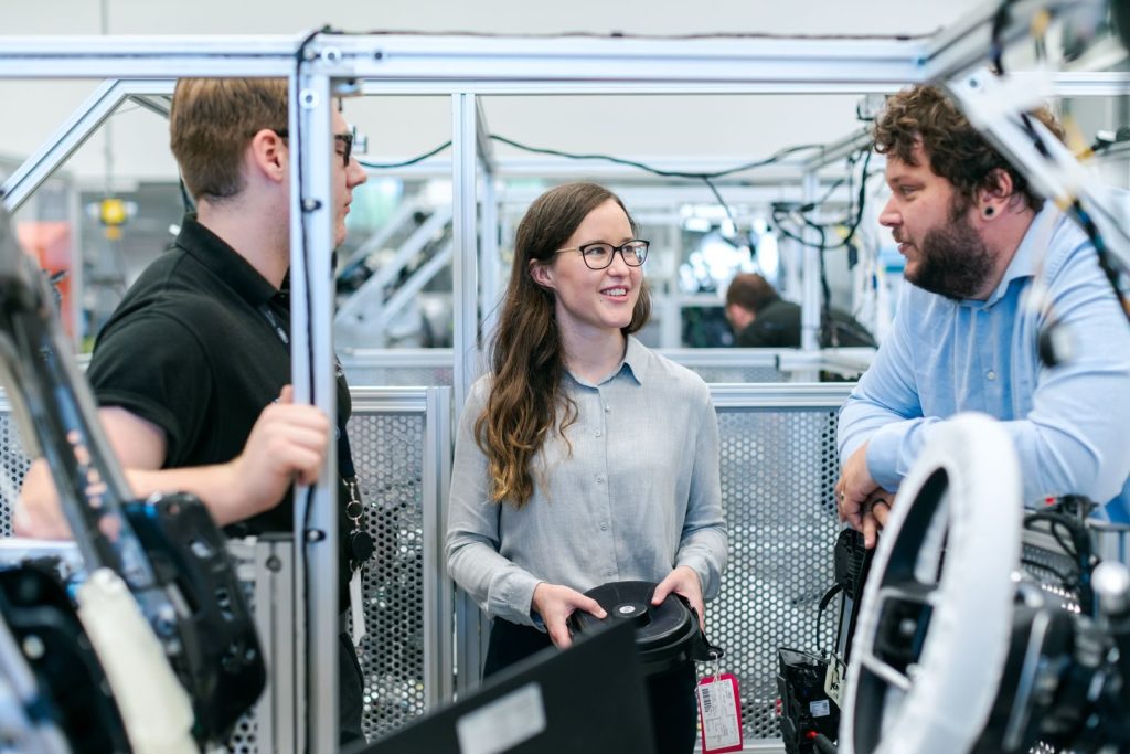 Group of engineers collaborating on a project in a tech-focused industrial setting.