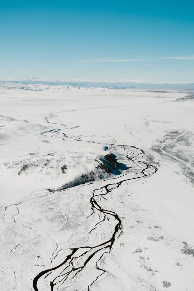 A breathtaking aerial view of a snow-covered landscape in Russia, showcasing frozen rivers and vast wilderness.