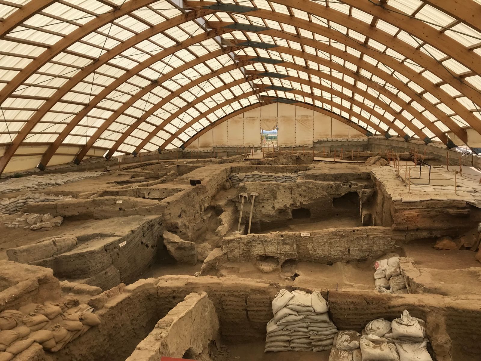 A large indoor archaeological dig showcasing ancient ruins under a protective dome structure.