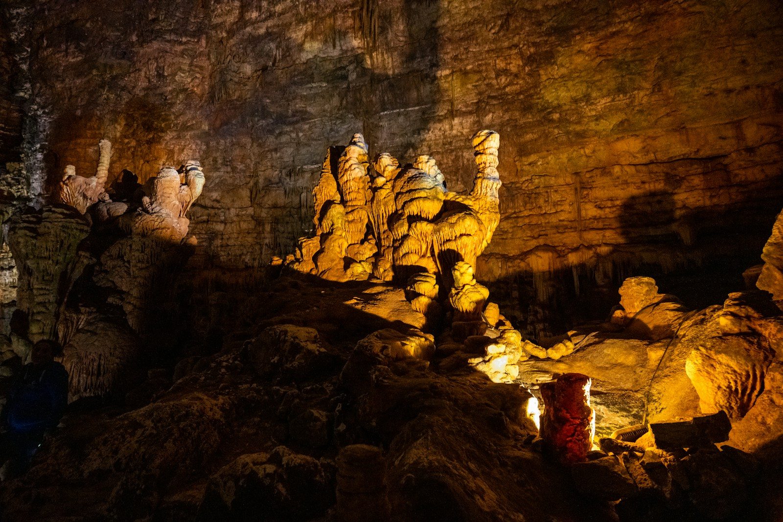Illuminated cave interior with ancient rock formations.