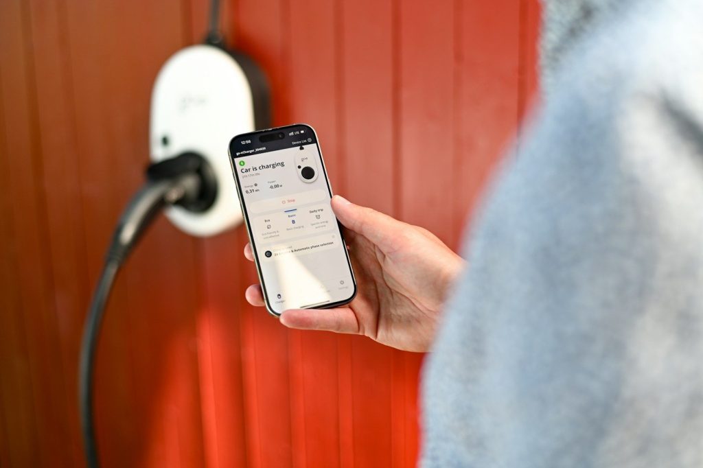 Person uses phone to control electric vehicle charger.