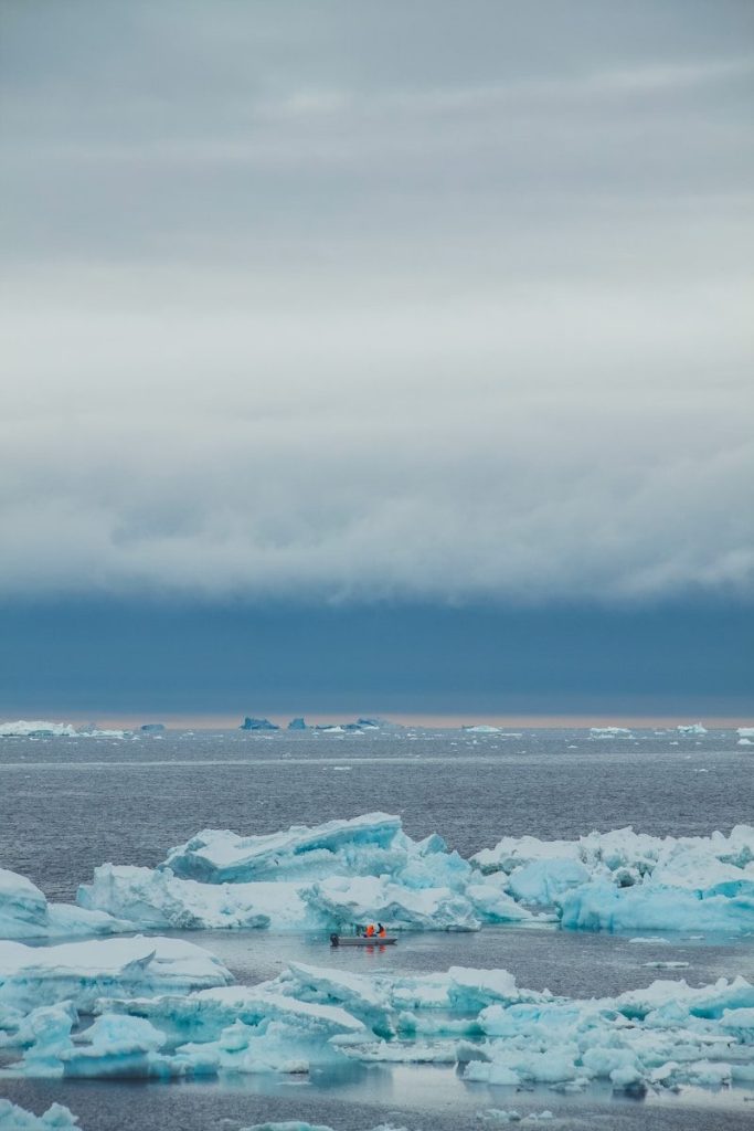 A large group of icebergs floating on top of a body of water