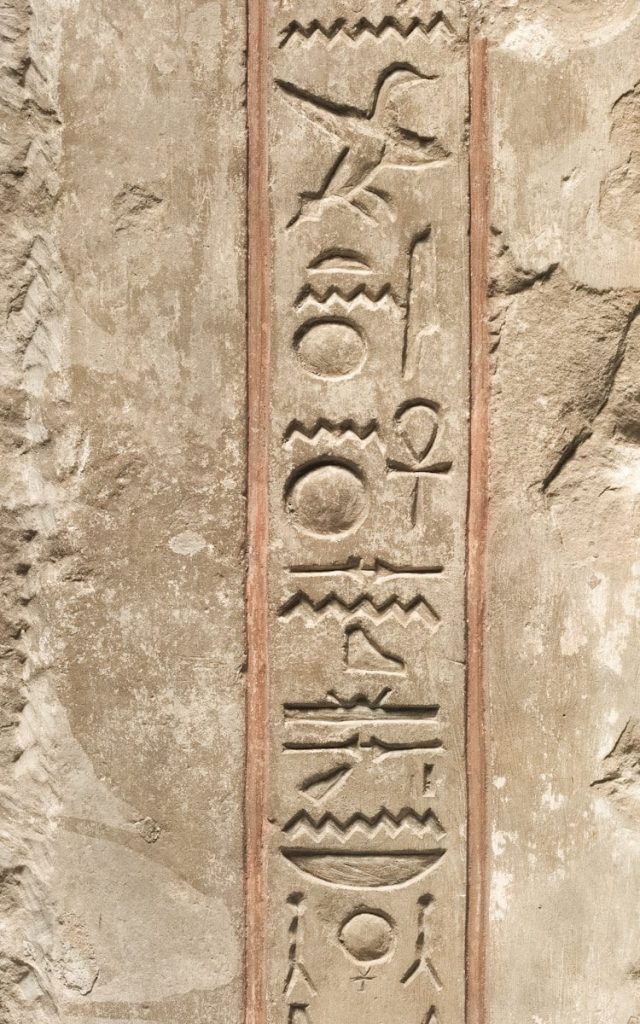 Ancient egyptian hieroglyphs carved into stone