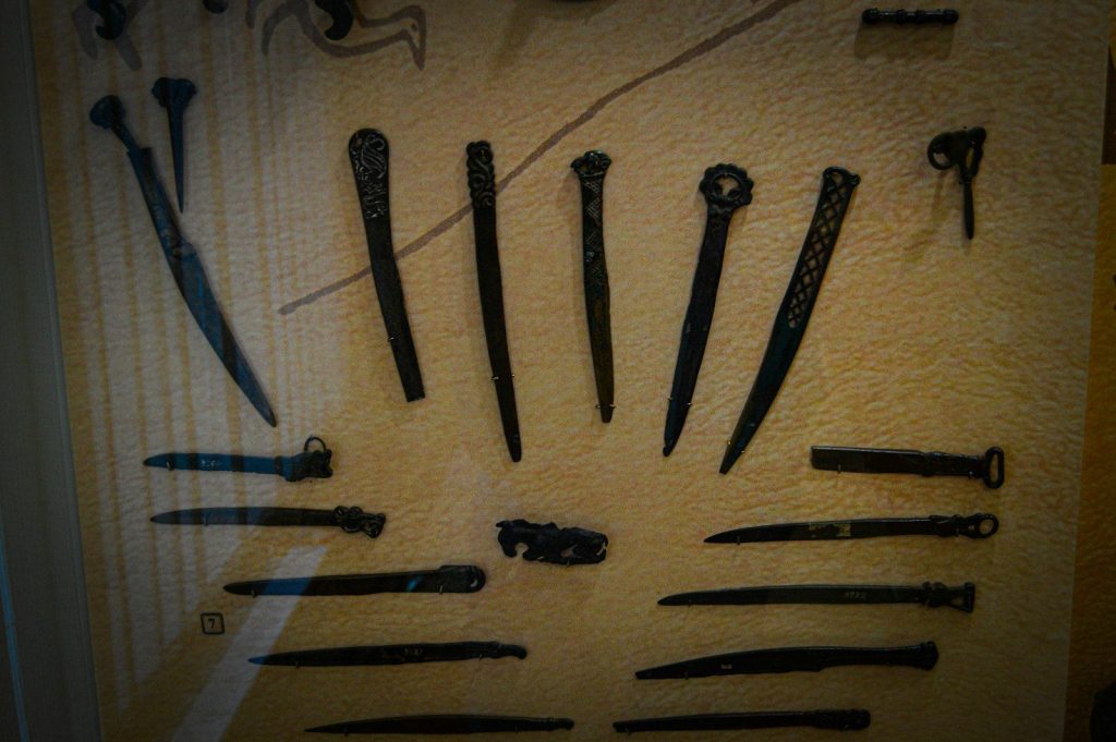 a bunch of knives are on display in a glass case