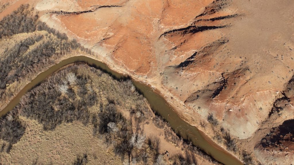 an aerial view of a river running through a desert