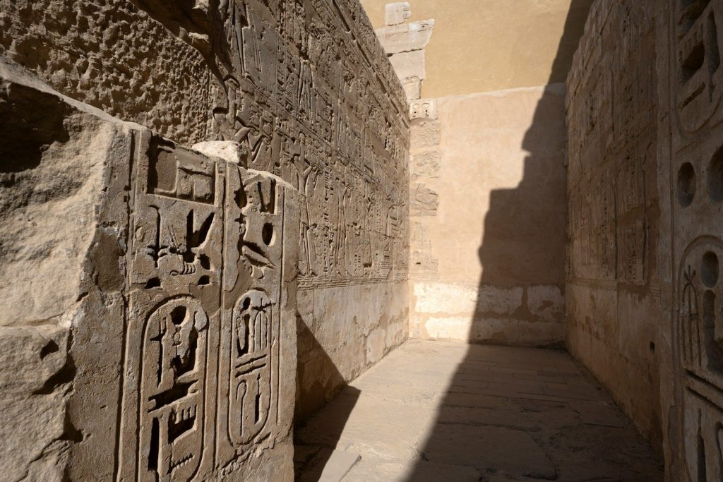 Ancient hieroglyphs carved into stone wall