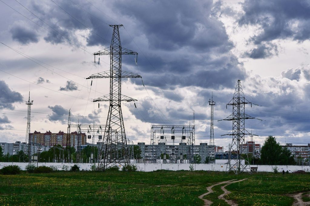a field with power lines and buildings in the background