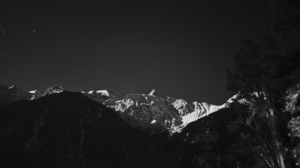 A black and white photo of a mountain at night
