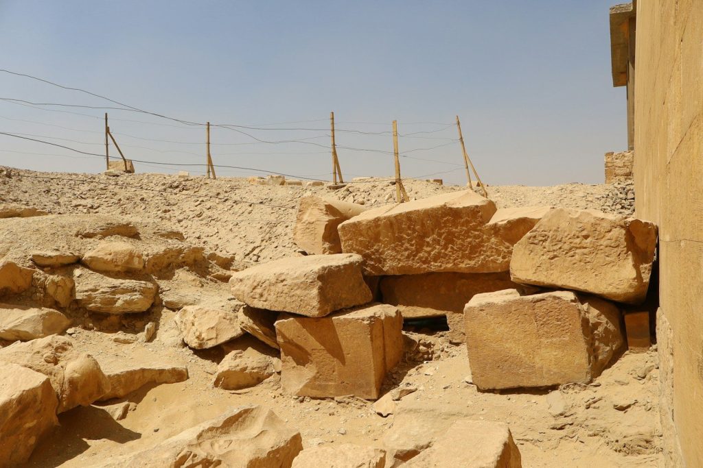 Large stone blocks piled in a desert landscape.