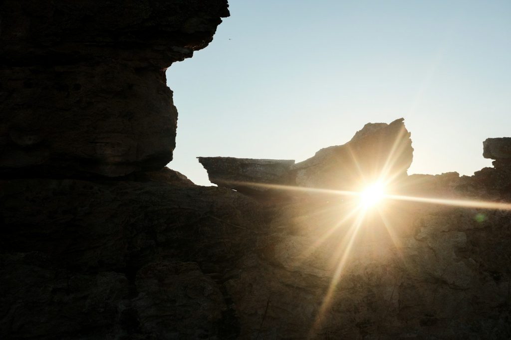 Sunlight bursts through the rocks.