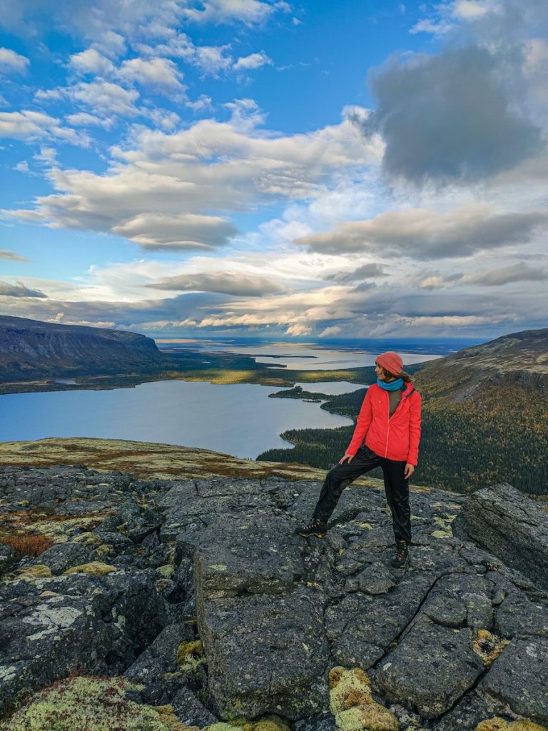 Woman in red jacket overlooks vast lake landscape