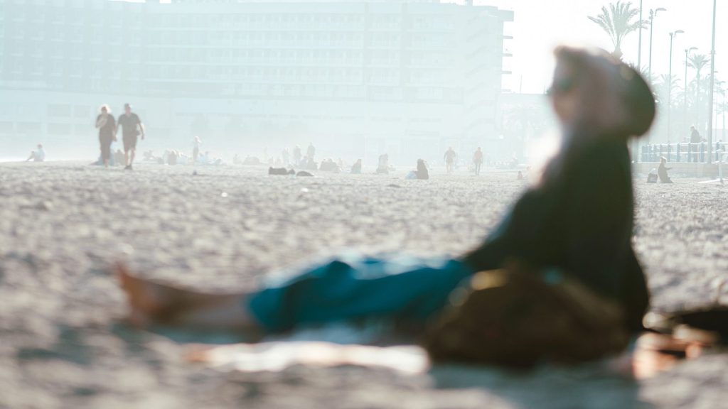 a person laying on a beach with a building in the background