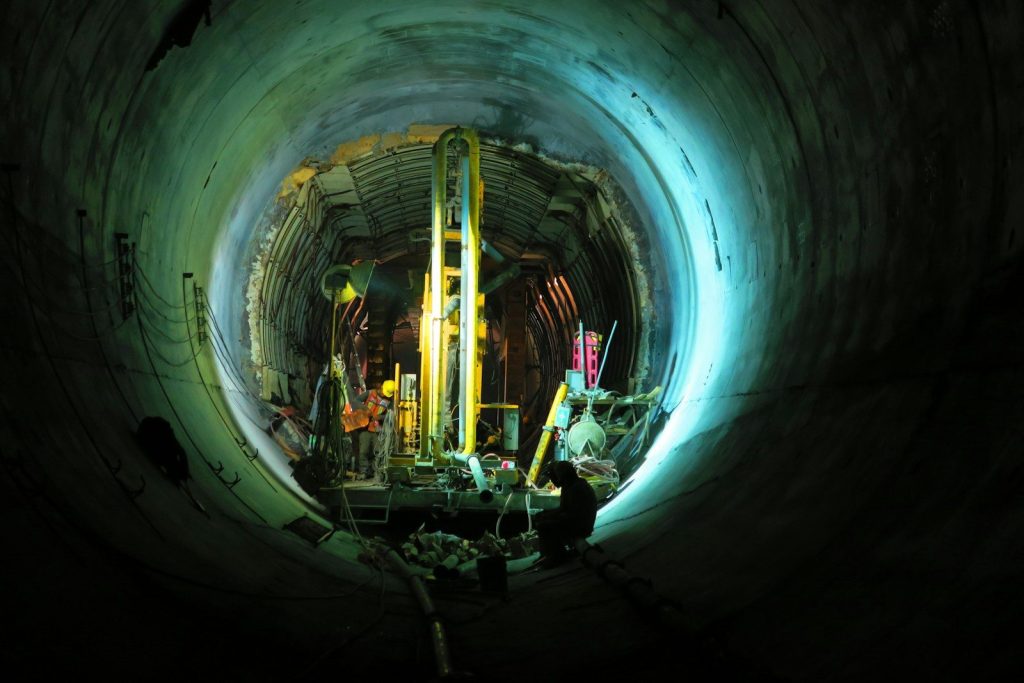 person sitting in tunnel near yellow turned on lamp