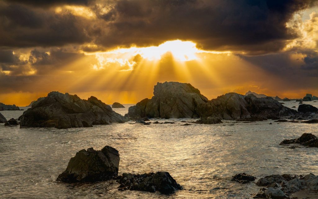 the sun is shining through the clouds over the ocean
