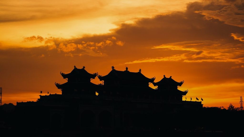 a silhouette of a building and a sunset