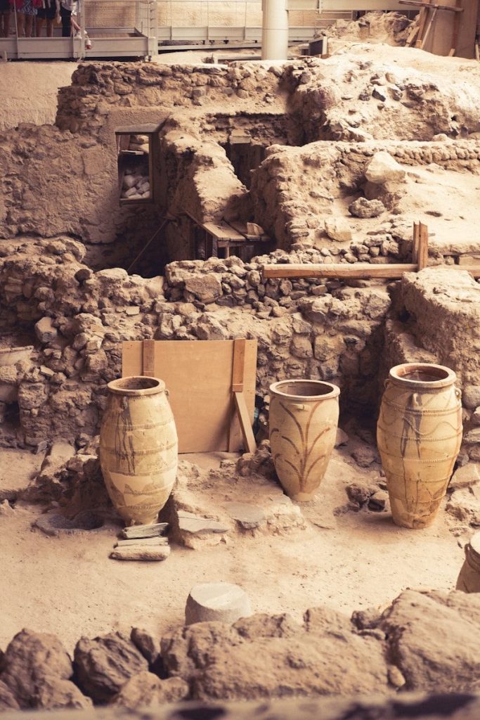 A group of clay pots sitting on top of a dirt field