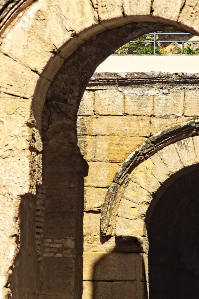 an arch in a stone building with a clock on it