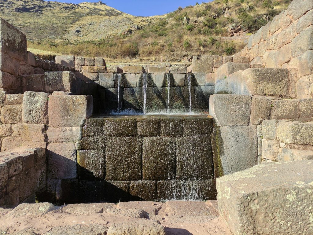 a water fall in the middle of a stone wall