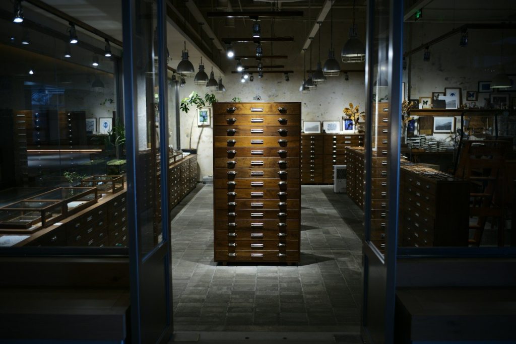 Antique wooden filing cabinets in a dimly lit room.